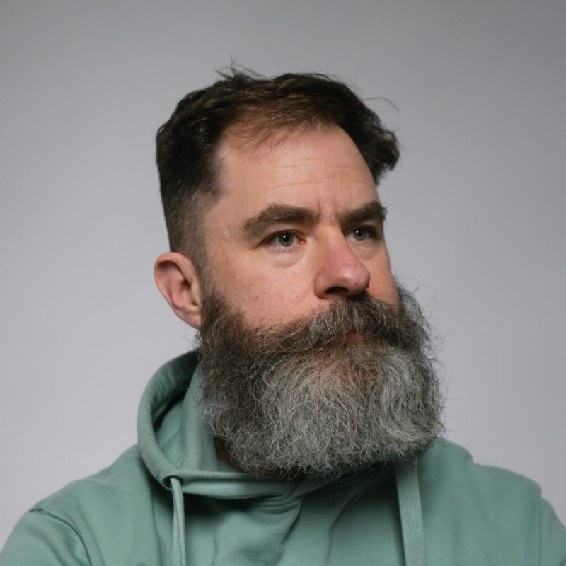 Will is a middle-aged white man with a ginormous greying beard. He is gazing into the middle distance wistfully. 